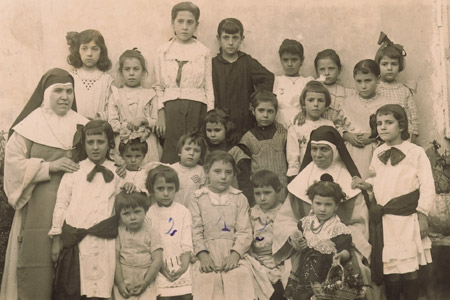 Escuela de Religiosas. Grupo de alumnos de la escuela Las Esclavas de Maria Inmaculada acompaado de 2 religiosas. La escuela estaba en la calle San Pascual esquina Calle Mayor. Foto del ao 1918.