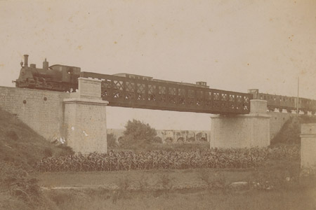Tren pasando por el Puente de Hierro. Lnea de ferrocarril de Valncia a Aragn inaugurado en 1889, de la cual slo se construy el tramo hasta Llria. El proyecto lo realiz Rafaell Valls. En la foto el tren en direccin Valncia.
